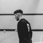 Black and white image of a volleyball player in jersey number 9 during a game.